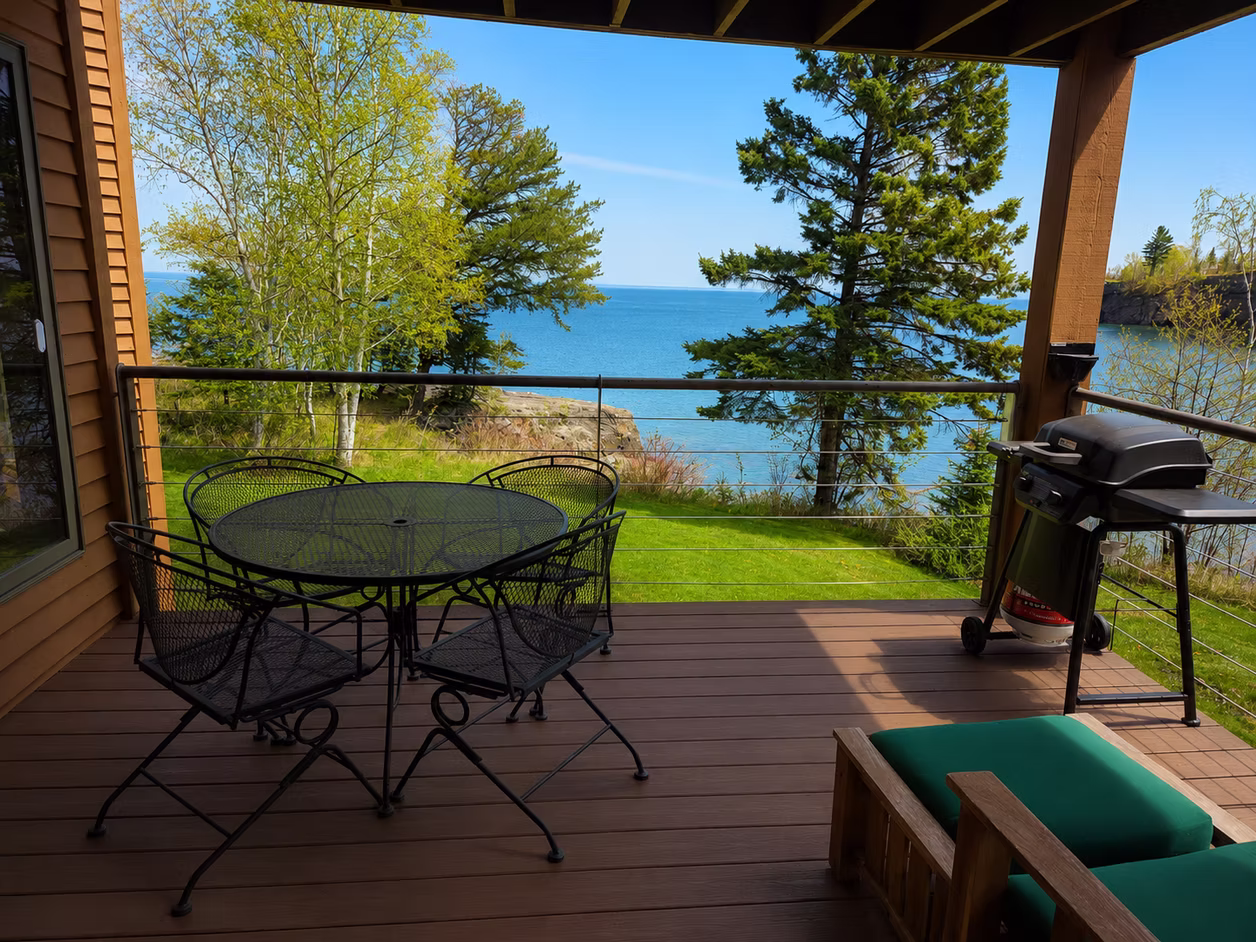 Lake home deck with patio table and grill overlooking the Lake Superior shoreline
