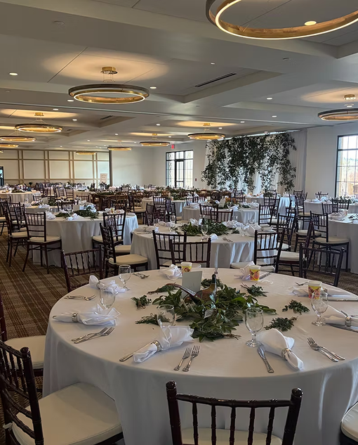 Ballroom set with round tables and greenery for an event at Superior Shores