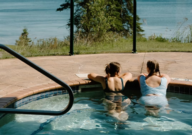 Guests relaxing in the outdoor hot tub above the Lake Superior shoreline