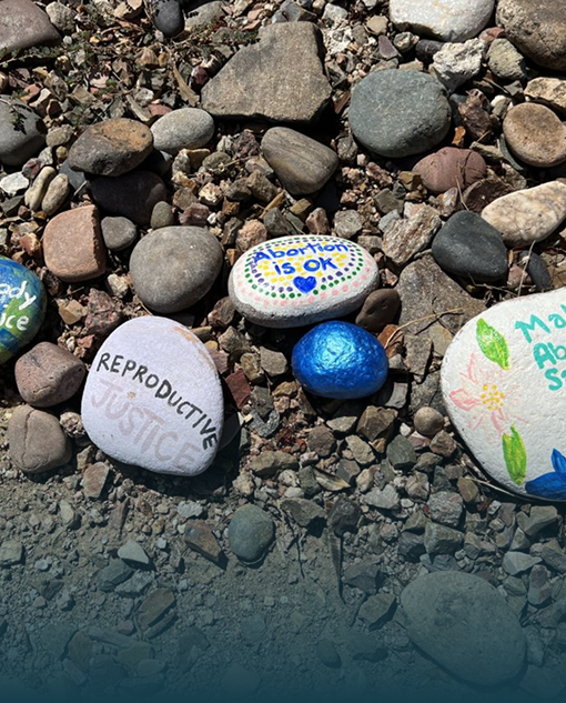 Painted rocks resting on the cobblestone Lake Superior beach