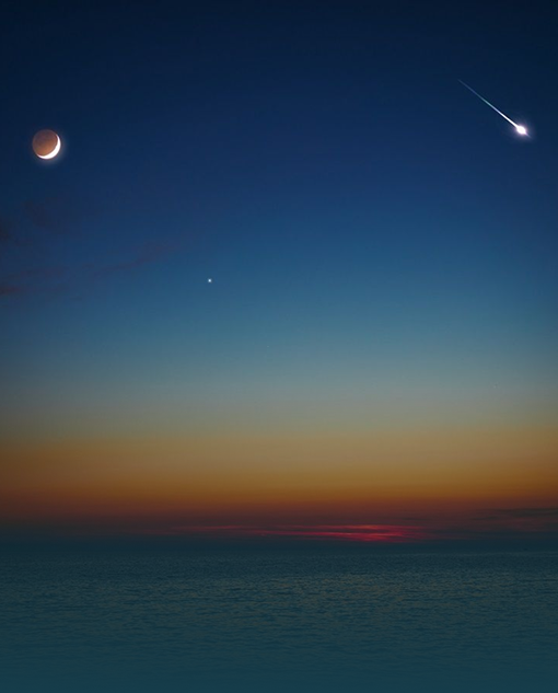 Crescent moon and shooting star over Lake Superior at twilight